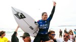 Female Surfer Johanne Defay hoisted up on her fan's shoulders after competiting in a surfing competition