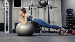 Fit female in the gym working out her core muscles with the stability ball stir to pot exercise